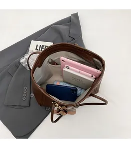 Spacious interior of a brown tote bag showing compartments for tablet and daily items