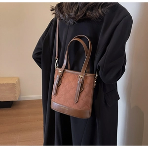 Braune gesteppte Eimertasche in Matten-Optik mit verstellbarem Riemen am Model gezeigt