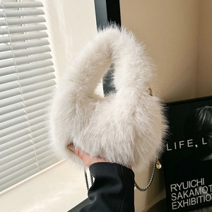 Bolso de mano de piel sintética blanca con cadena de perlas en un entorno minimalista