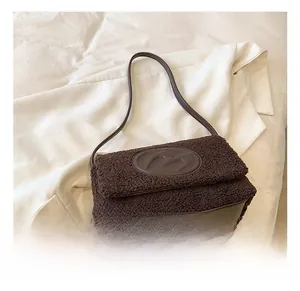 Detailed view of coffee brown lamb wool texture and leather strap on a shoulder bag