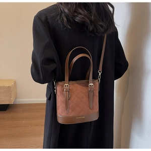 Details einer braunen gesteppten Beuteltasche mit Fashion & Bags Aufdruck am Boden