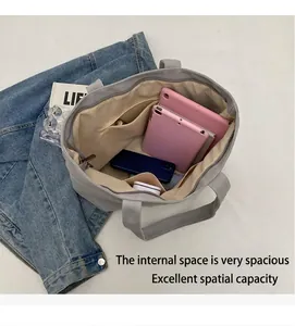 Interior espacioso del bolso de lona con compartimentos para tabletas y móviles