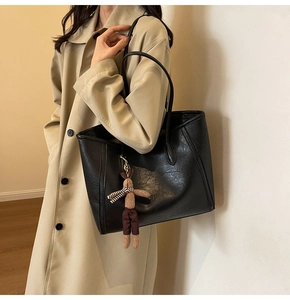 Large black PU leather tote bag with a brown rabbit plush pendant shown on a shoulder