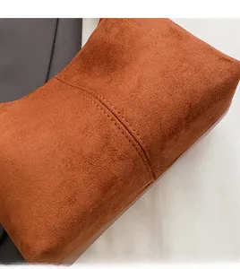 Close-up of high-quality stitching and matte PU suede texture on brown crescent bag