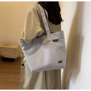 Detalle del bolso tote de lona con etiqueta tejida y estampado de logotipo artístico