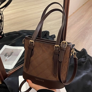 Braune Retro-Eimertasche aus Mattleder mit Steppnähten und verstellbaren Henkeln