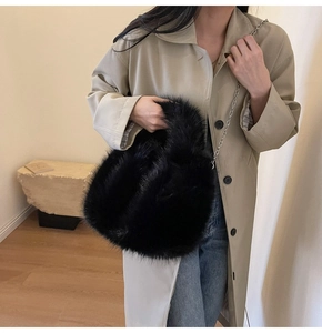 Détail d'un sac à main en fausse fourrure noire avec une chaîne argentée élégante