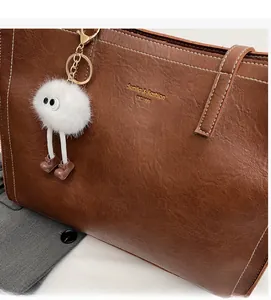 Détail du sac cabas marron en similicuir avec surpiqûres blanches et charme peluche