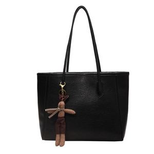 Large black faux leather tote bag with long handles and a cute bunny pendant charm
