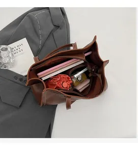 Vue intérieure du cabas en cuir marron montrant sa grande capacité pour tablette et objets