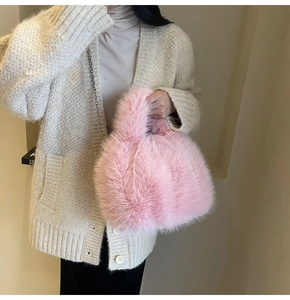 Gros plan du sac à main en peluche rose avec bandoulière en chaîne argentée