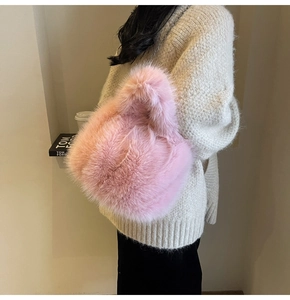 Détail du sac à main en fausse fourrure rose avec chaîne argentée porté par un mannequin