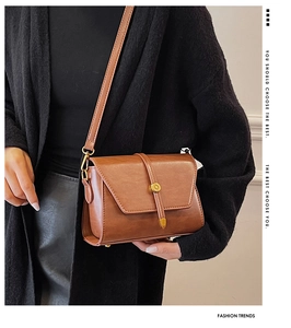 Détail d'un sac bandoulière en cuir PU marron avec boucle dorée vintage ronde