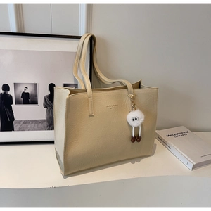 Détail du sac cabas beige avec logo Sunilla Fashion et charmant pendentif en peluche