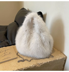 Détail d'un sac à main en fausse fourrure blanche avec bandoulière chaîne argentée