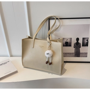 Détail du grand sac cabas blanc crème à texture plissée avec accessoire en peluche