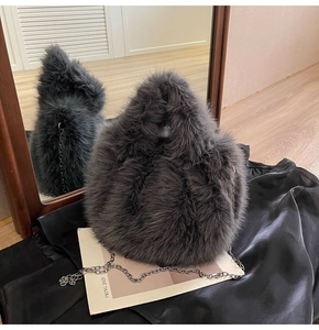 Détail d'un sac à bandoulière en fausse fourrure gris foncé avec chaîne argentée