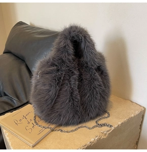 Détail de la texture en fausse fourrure grise avec bandoulière chaîne argentée