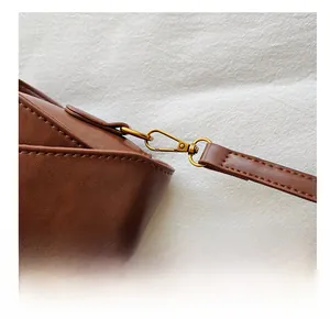 Détail du crochet en métal bronze de qualité sur le sac en cuir PU marron