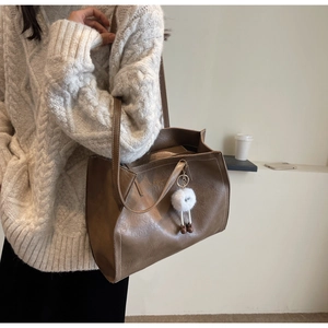 Détail du sac cabas marron café avec coutures blanches contrastées et charm en peluche