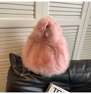 Détail de la texture d'un sac en fausse fourrure rose avec chaîne en métal argenté