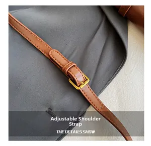 Détail de la bandoulière réglable en similicuir avec boucle dorée pour sac à bandoulière