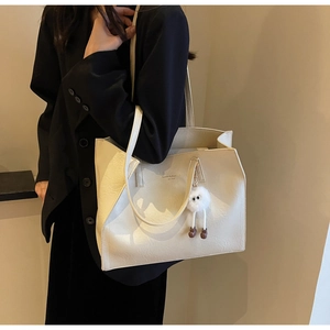 Détail du grand sac cabas crème avec texture grainée et pendentif peluche mignon