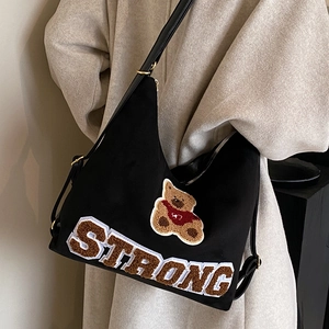 Retro black canvas shoulder bag with plush bear patch and Strong embroidery detail