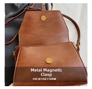 Détail de la boucle magnétique dorée sur un sac bandoulière marron en cuir PU