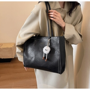 Détail du grand sac cabas noir avec coutures blanches et breloque en peluche