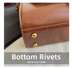 Détails du fond d'un sac en cuir PU marron avec rivets de protection en métal doré