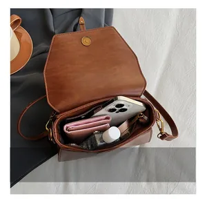 Vue intérieure du sac bandoulière en similicuir marron montrant sa capacité de rangement
