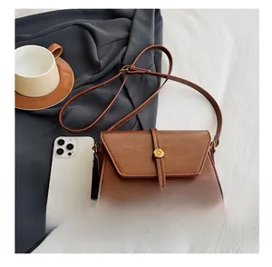 Détails macro du sac à bandoulière en similicuir marron avec boucle dorée élégante