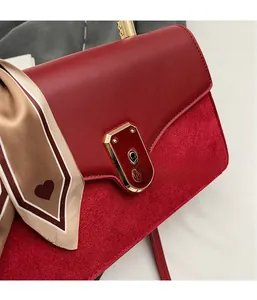 Close-up of red PU leather bag with velvet texture contrast and heart pattern scarf