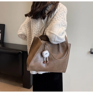 Vue arrière détaillée d'un grand sac cabas marron en simili cuir avec pendentif peluche