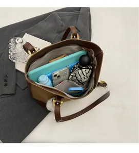 Detail view of spacious tote interior with compartments, tablet, and umbrella