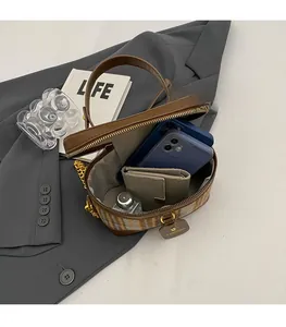 Top view of open brown vanity bag showing spacious interior with herringbone lining