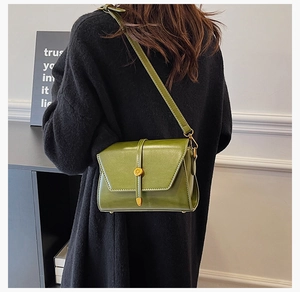 Détail du petit sac carré en cuir PU vert foncé avec boucle dorée et pieds de sac