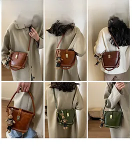 Détail d'un sac seau vintage avec boucle en métal et décoration de breloque lapin