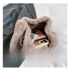 Capacity view of khaki plush bucket bag showing phone and cosmetics inside with silver chain