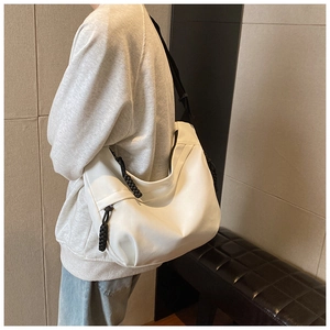 On-body view of a white oversized dumpling bag with a black woven zipper pull