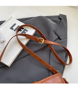 Détail de la bandoulière réglable en similicuir marron avec boucle en métal doré chic