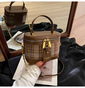 Detail of vintage brown plaid vanity bag with gold chain strap and leather handle