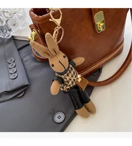 Détail d'un bijou de sac lapin avec fermoir doré sur un sac à main en cuir marron