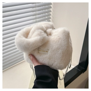 Detail of soft white faux fur bucket bag with silver chain and Have Every Day gold text