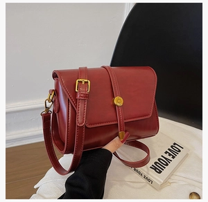 Détail du sac vintage bordeaux en cuir PU avec boucle dorée et bandoulière réglable