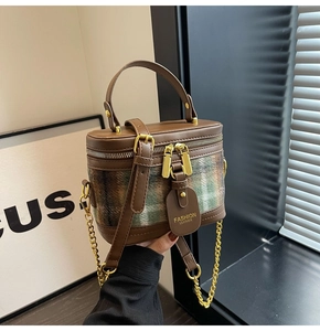 Detail of vintage plaid bucket bag with gold chain strap and dual zippers