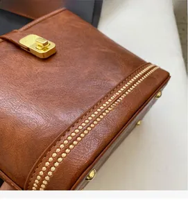 Détail de la texture en similicuir marron caramel avec élégant fermoir rotatif doré