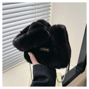 Close-up of black faux fur bucket bag with silver chain and a love every day label