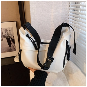 Detail of white crescent bag with black nylon strap and plastic buckle closure